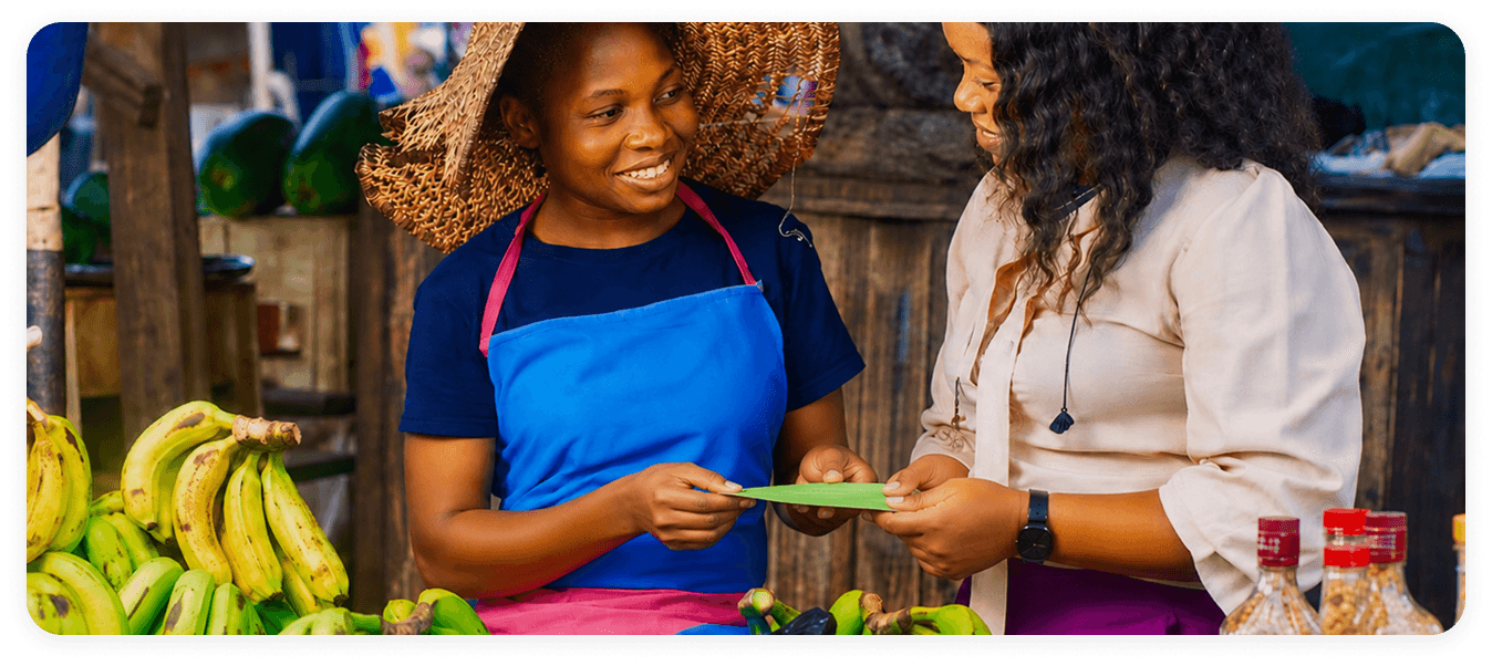 Two people at a market exchanging a contribution card